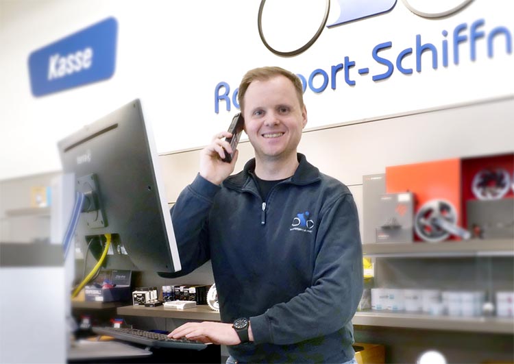 ueberuns-team-schiffner-02 Radsport Schiffner Mitarbeiter an der Kasse mit Telefon freundlich